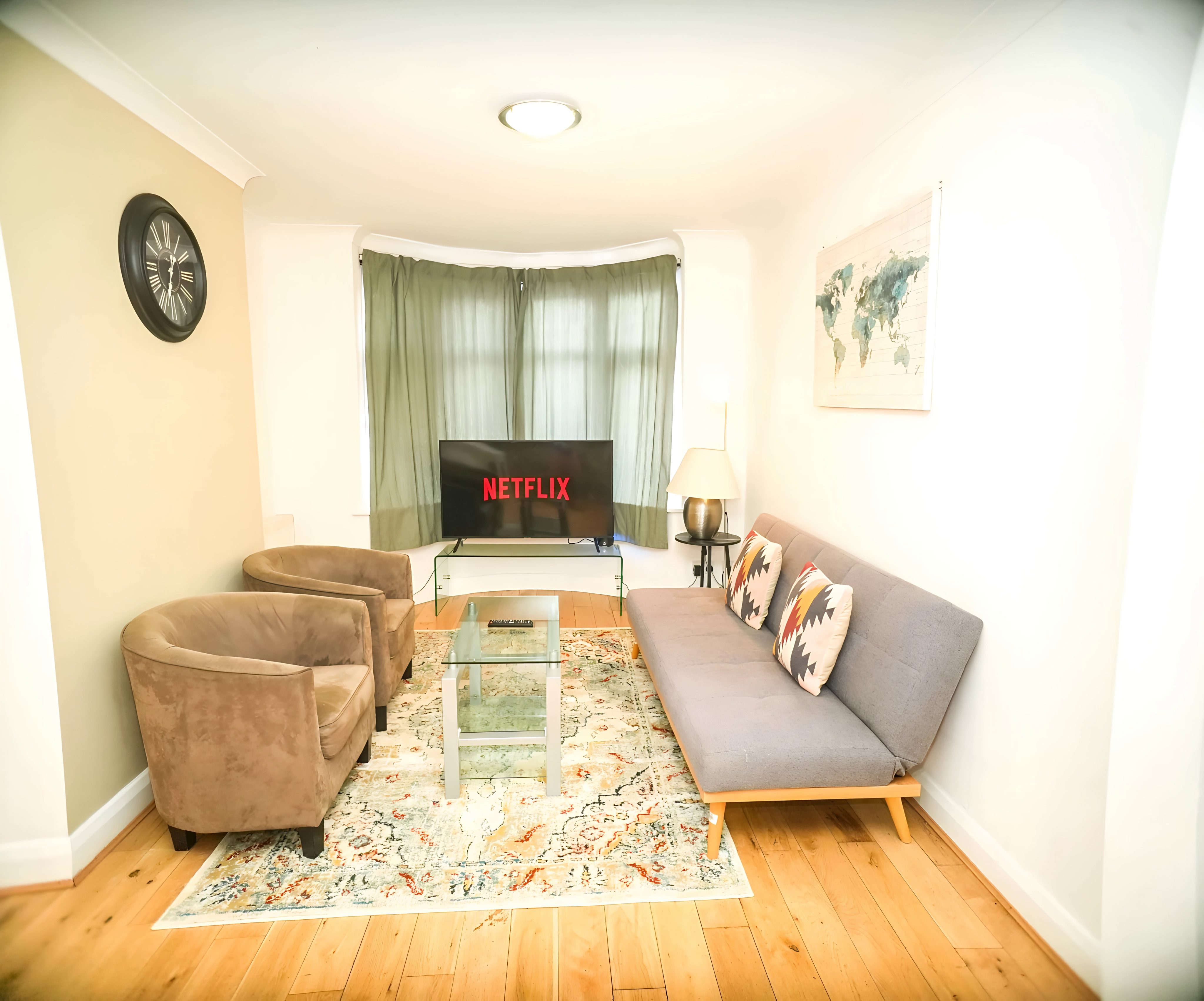 Living room at the Feltham 3-Bedroom Home, with grey sofa, armchairs and TV
